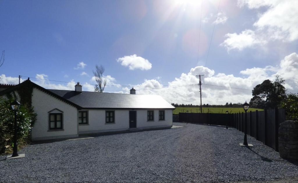 a small white house with a gravel driveway at Ashford Villa in Cong