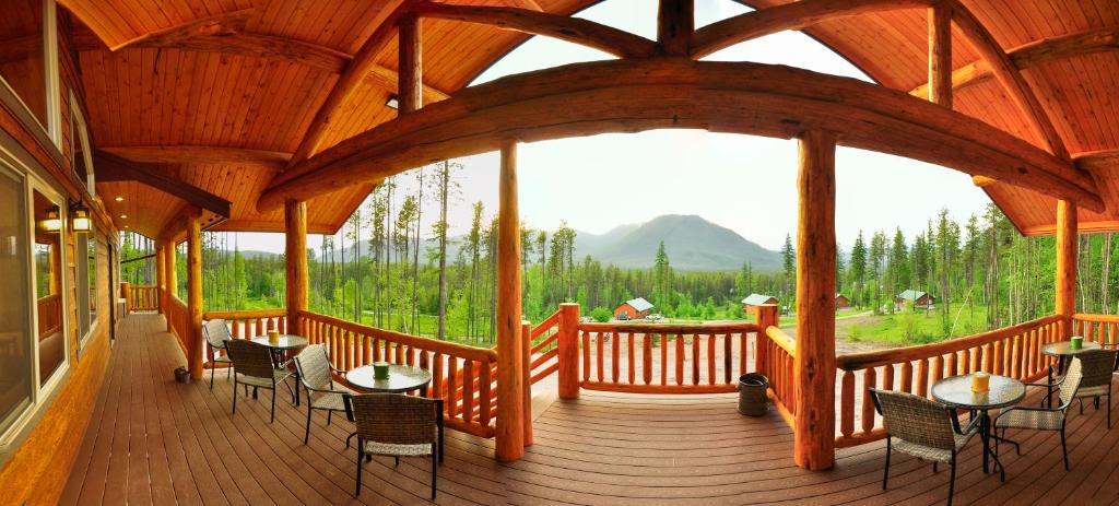 a large wooden porch with tables and chairs on it at Paddle Ridge in West Glacier