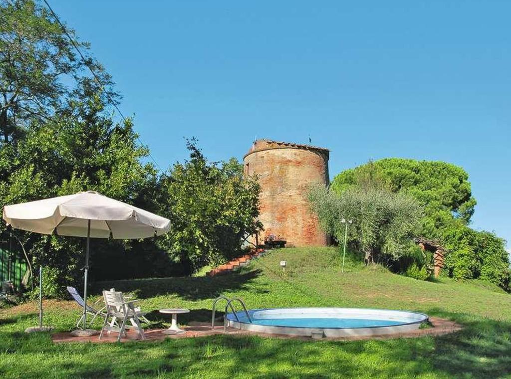 FaugliaにあるMulino a ventoの城の前の傘とプール