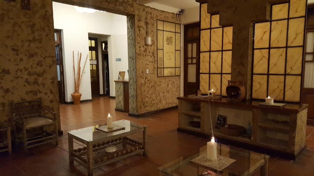 - un salon avec des bougies sur une table et des fenêtres dans l'établissement Refugio del Inca, à Salta
