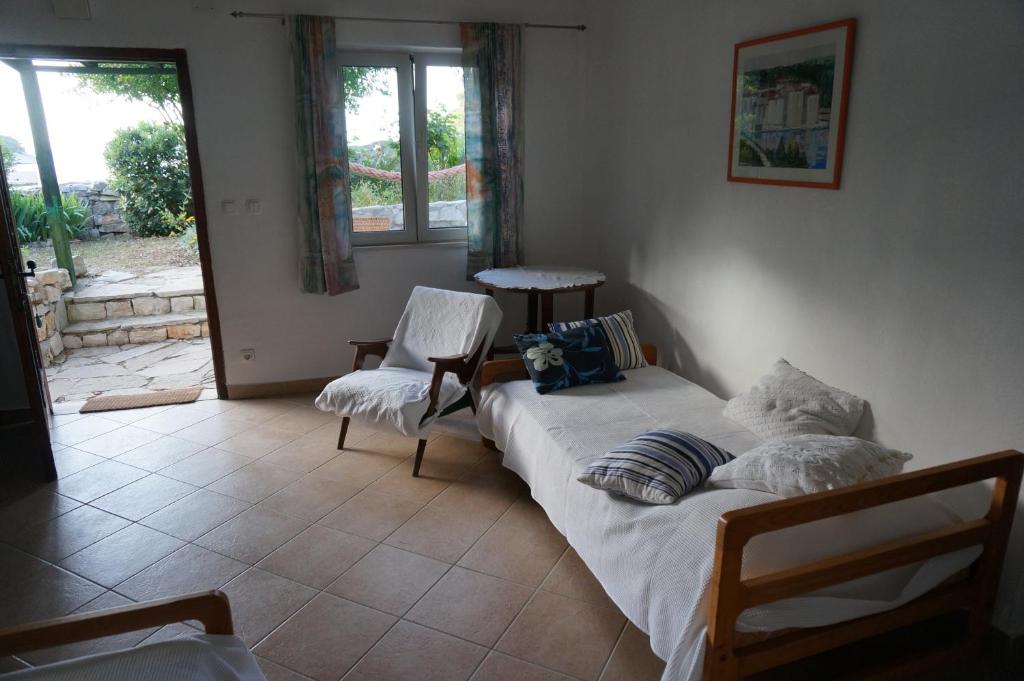 sypialnia z dwoma łóżkami i krzesłem w obiekcie Apartment Stiniva w Hvarze
