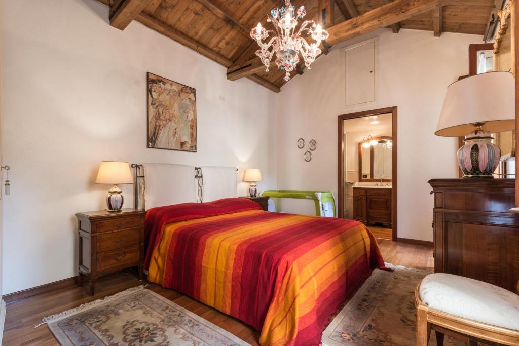 a bedroom with a colorful bed and a chandelier at Serenissima in Venice