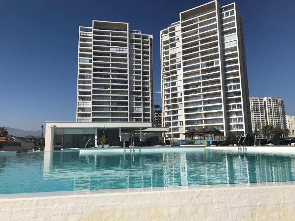 a swimming pool in front of two tall buildings at Apartamento Playa y Casino in Coquimbo