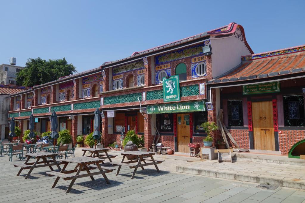 a building with picnic tables in front of it at 八八小屋心享民宿 in Jinning
