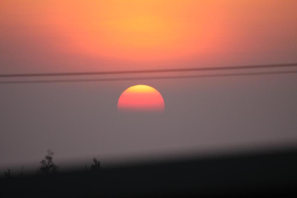 an orange sun is rising through the clouds at 八八小屋心享民宿 in Jinning
