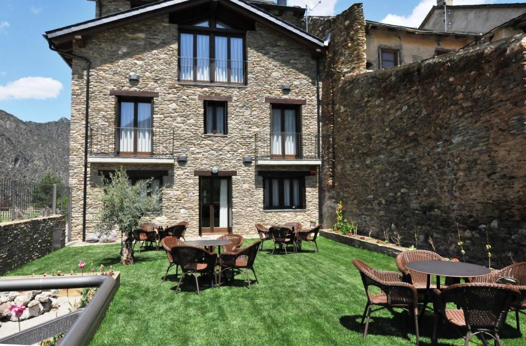 a patio with tables and chairs in front of a building at Allotjament rural La Comella de Tírvia in Tirvia