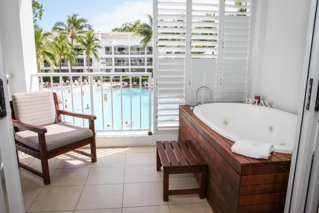 a bathroom with a tub and a chair and a window at 3121 "SHILOH" AT THE BEACH CLUB in Palm Cove