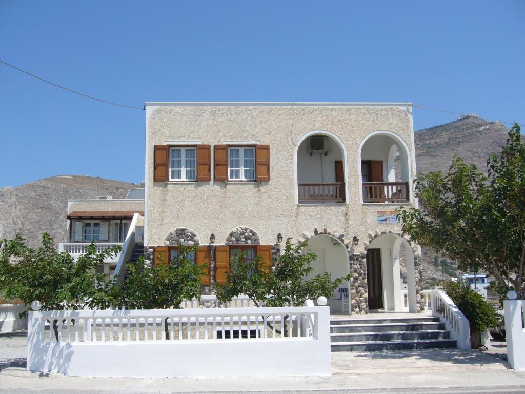 una casa con una cerca blanca delante de ella en Margarita, en Perissa