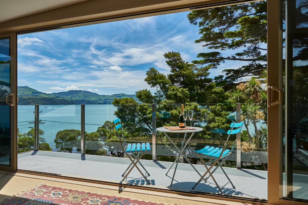a view from the balcony of a house with a table and chairs at Akaroa on the Beach in Akaroa