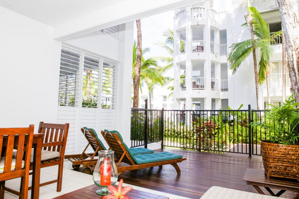 a screened porch with chairs and a table at 5313 BEACH CLUB CORAL SUITE in Palm Cove