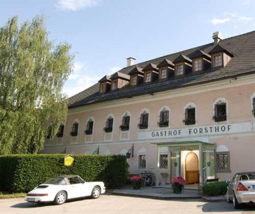 ein weißes Auto, das vor einem Gebäude parkt in der Unterkunft Landhotel Forsthof in Sierning