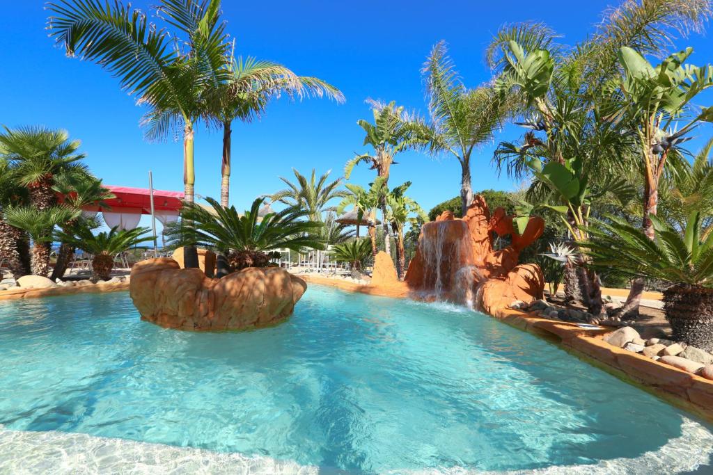 einen Pool in einem Resort mit Wasserfall in der Unterkunft Résidence & SPA Marina d'Arone in Piana