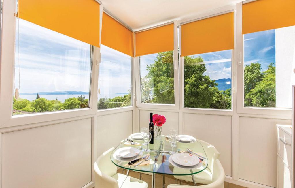a dining room with a glass table and windows at Apartment San in Rijeka