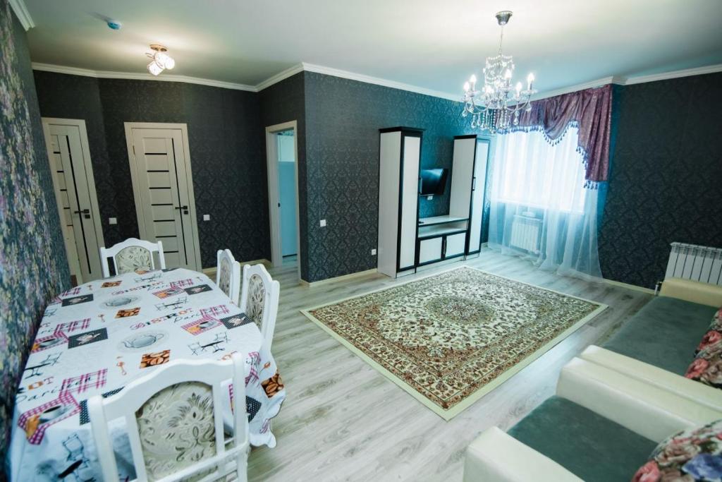 Cette chambre comprend une table et des chaises blanches. dans l'établissement Apartments on 7/1 Sarayshyq, à Astana