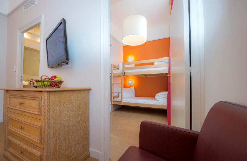 a small room with a bedroom with bunk beds at Hôtel Miléade L'Orangeraie - Menton in Menton
