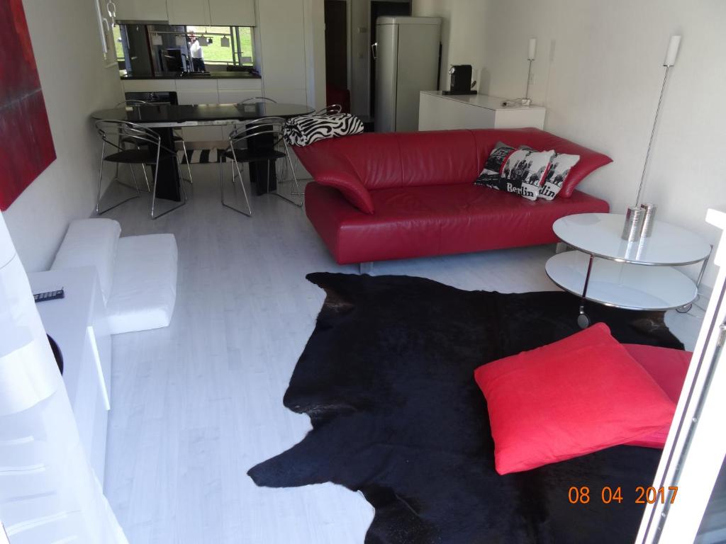 salon z czerwoną kanapą i czerwoną poduszką w obiekcie Haus Montanara w mieście Unterbäch