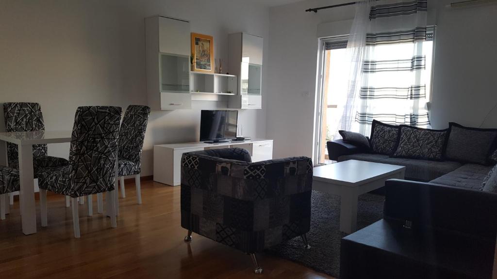 een woonkamer met een bank en een tafel en stoelen bij Zebra in Podgorica