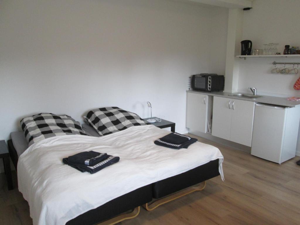 een slaapkamer met een bed met zwart-witte kussens bij Hos Tina in Roskilde