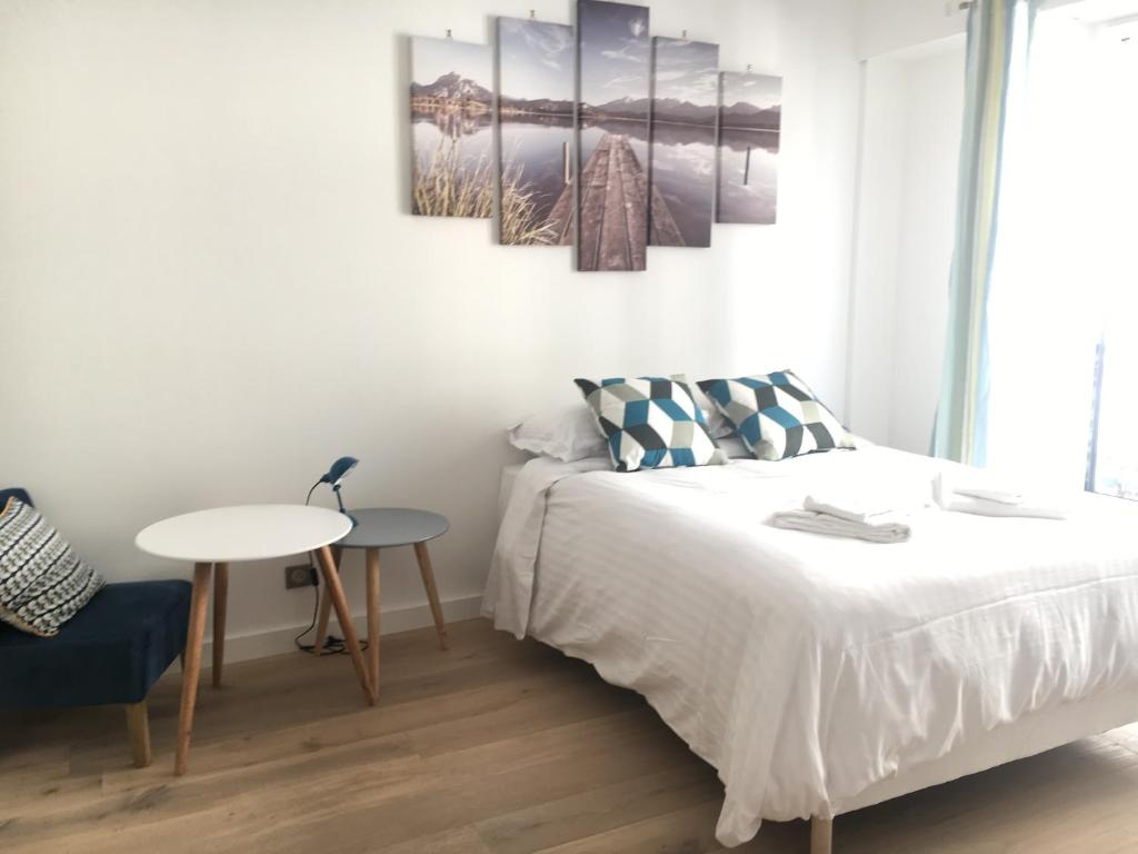 a white bedroom with a bed and a table at Eve in Cannes