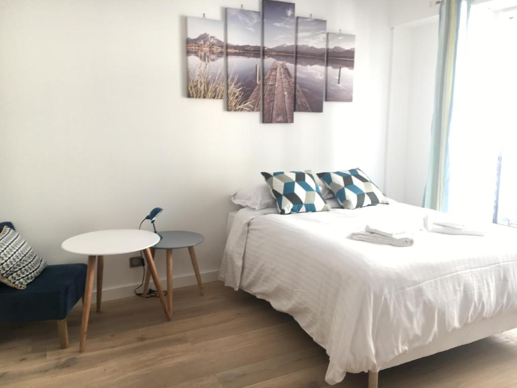 une chambre blanche avec un lit et une table dans l'établissement Eve, à Cannes