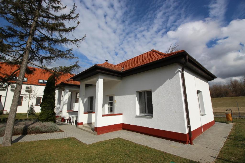 a white house with a red roof at Gyevitur Apartman in Algyő