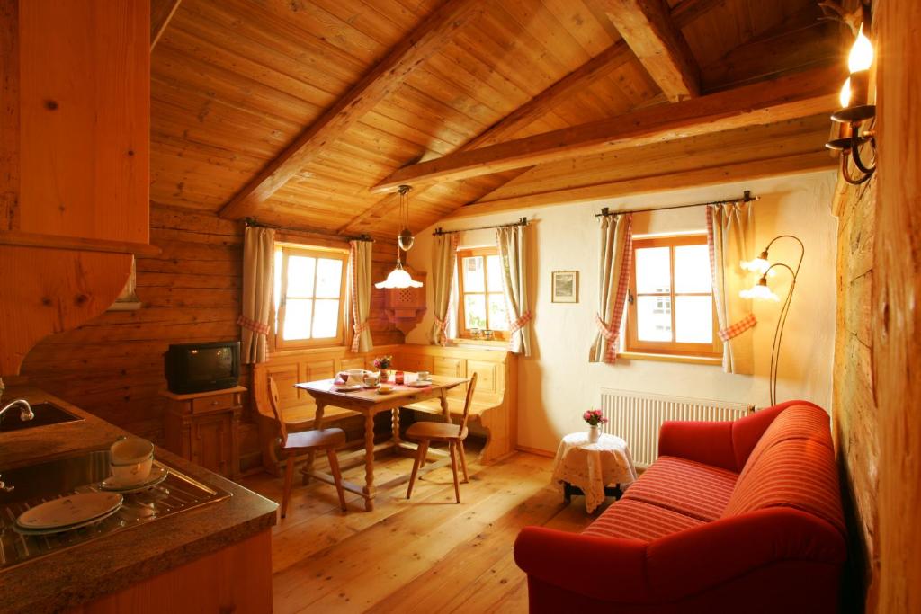 ein Wohnzimmer mit einem roten Sofa und einem Tisch in der Unterkunft Das Baderhaus in Zell am See