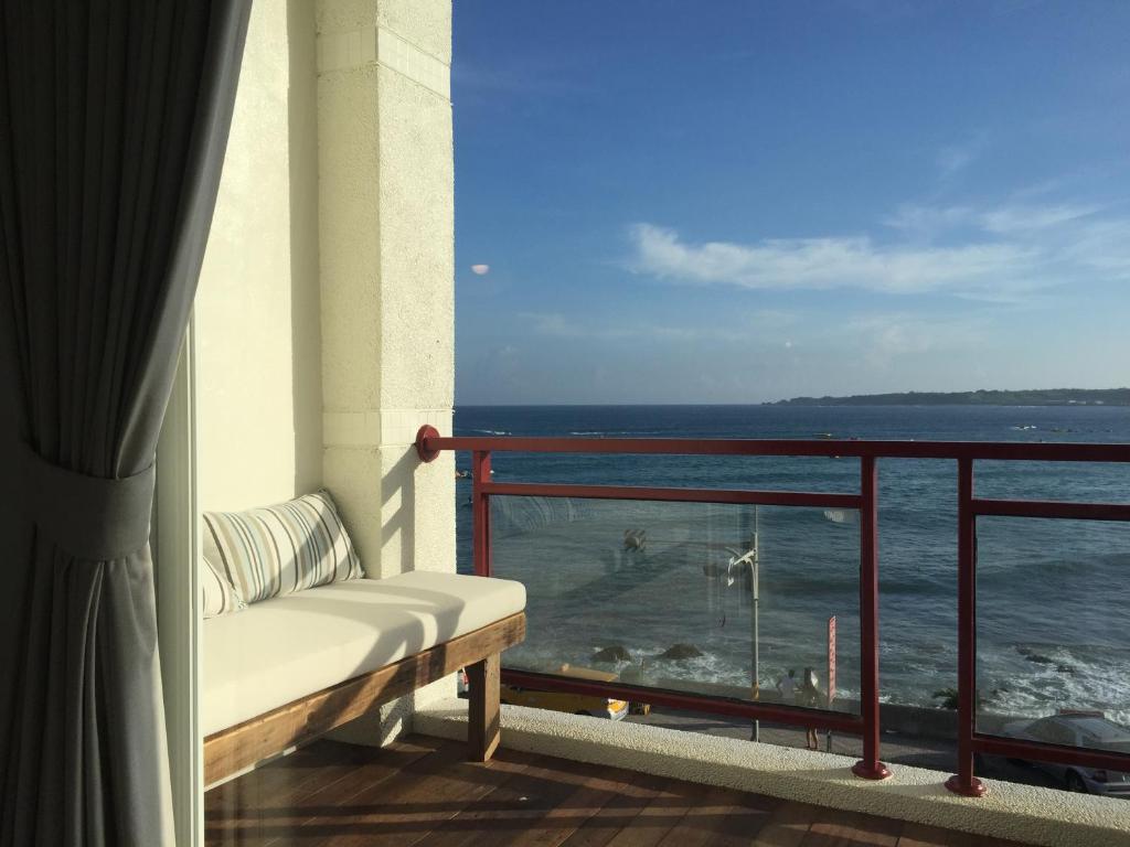a balcony with a bench looking out at the ocean at il Piccolo Polpo Hotel in Nanwan