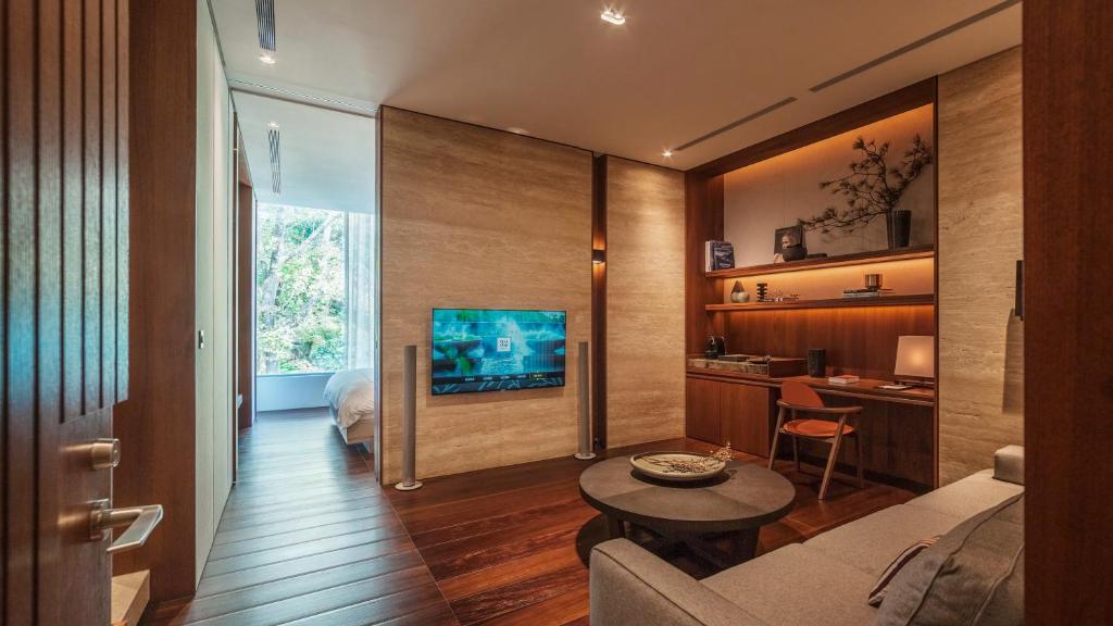 ein Wohnzimmer mit einem Sofa, einem Tisch und einem TV in der Unterkunft Villa 32 (Guests must be 16+) in Taipeh