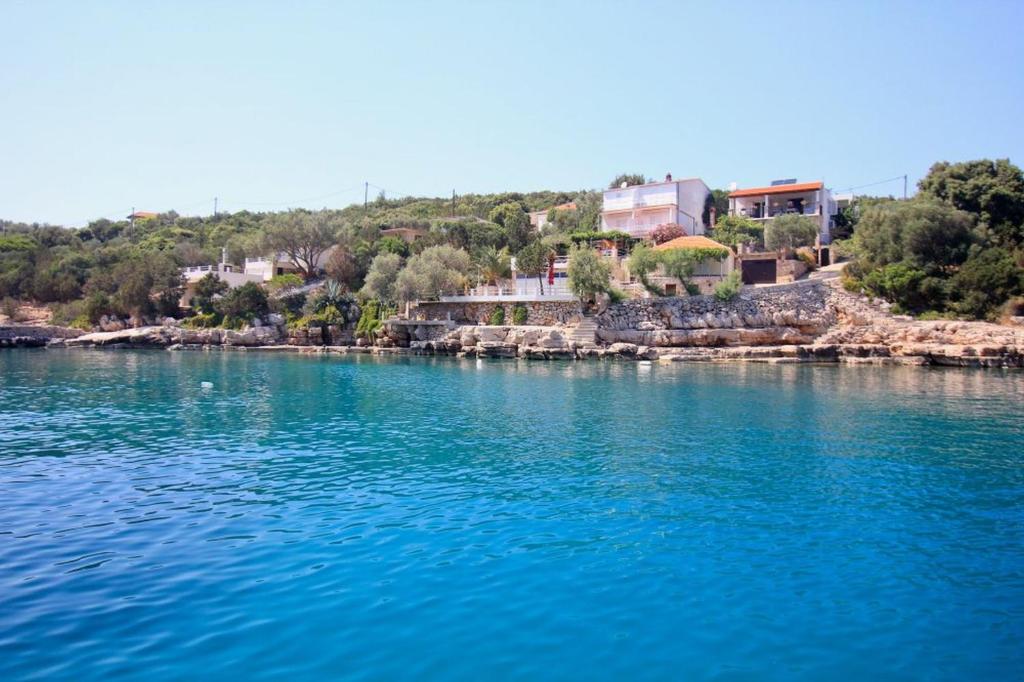 a large body of water with houses on the shore at Robinson Leonardo in Gdinj