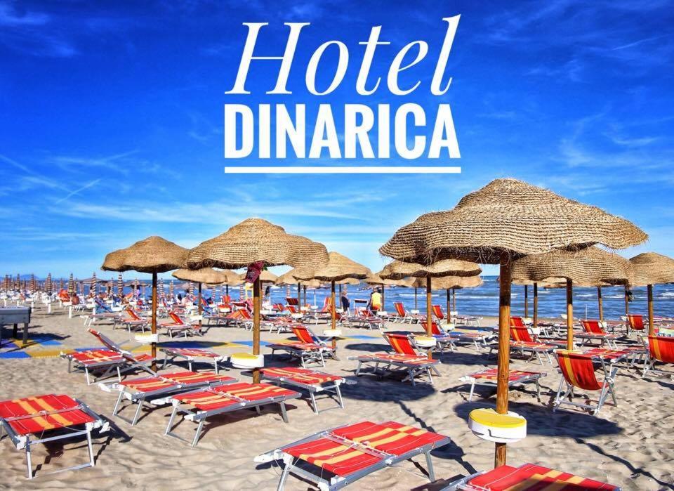 a view of a beach with chairs and umbrellas at Hotel Dinarica in Marotta