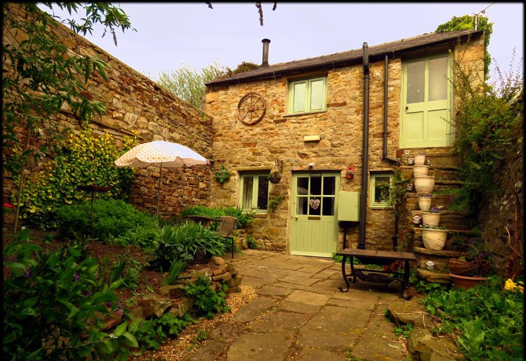 リースにあるThe Little Barnの緑の扉と傘を持つ石造りの家