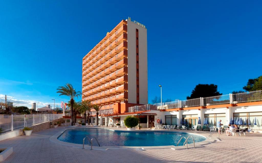 un hôtel avec une piscine en face d'un bâtiment dans l'établissement Hotel Cabana, à Benidorm