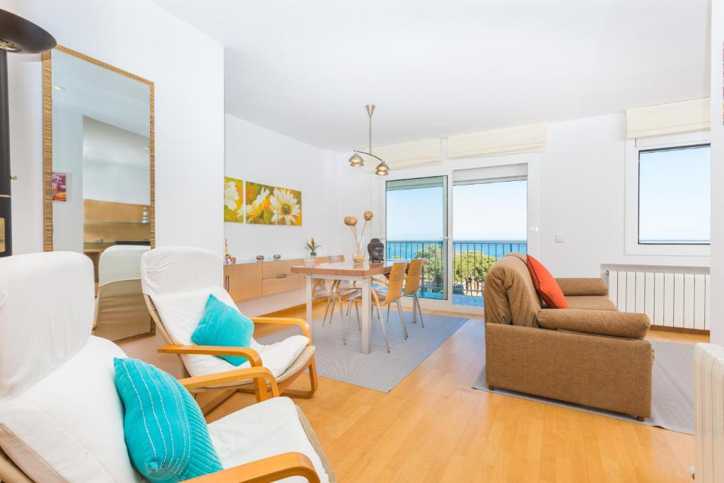 een woonkamer met witte meubels en een eetkamer bij Malgrat de Mar Blvd Seaview Apartment in Malgrat de Mar