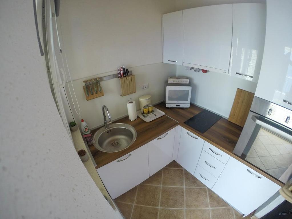a small kitchen with a sink and a microwave at Apartment and room Sveti Jakov in Dubrovnik