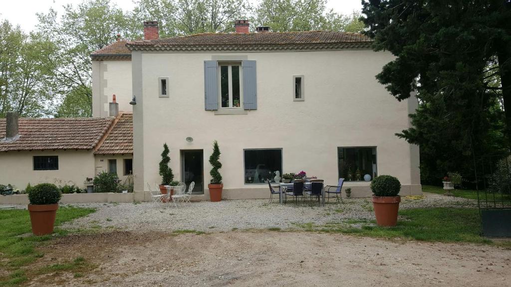 a large white house with a table and chairs at Manoir en Crau in Arles