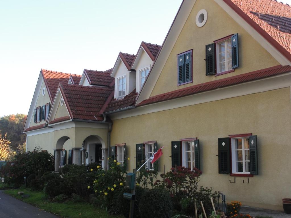 a yellow house with red roof and black windows at Maglanderhof in Unterlamm
