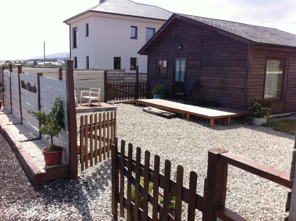 un patio trasero con una valla y una cabaña en Villas Eldorado-Mascotas Bienvenidas, en Barreiros