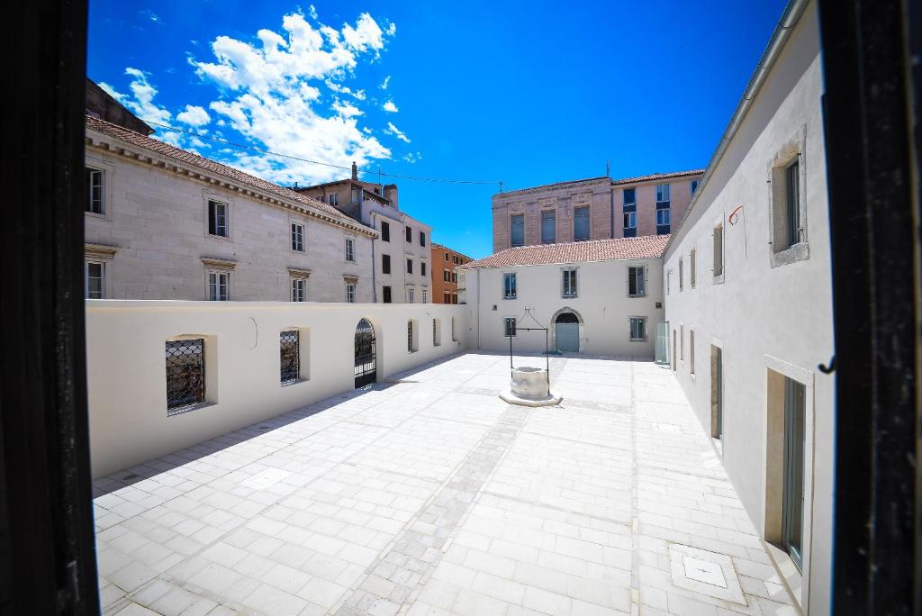 an empty courtyard in a city with buildings at Apartment and Room Soul of Dalmatia in Zadar
