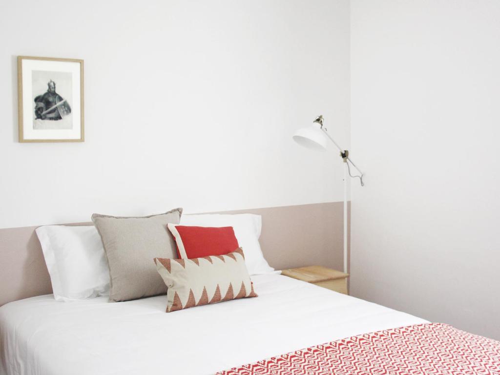 um quarto com uma cama branca com almofadas em Foral Guest House - Óbidos em Óbidos