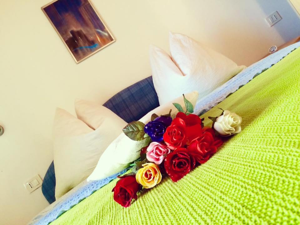 a bouquet of roses sitting on a bed at Apartment Emanuela in Rovinjsko Selo