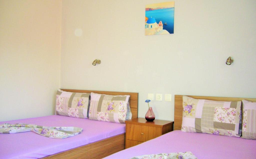 A bed or beds in a room at Vordos Rooms
