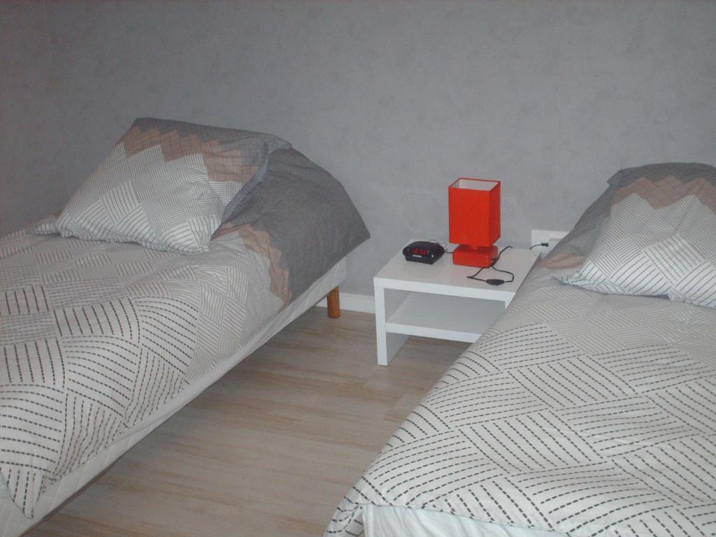 a bedroom with two beds and a table with a book at Meublé de tourisme*** letrilogis in Joinville