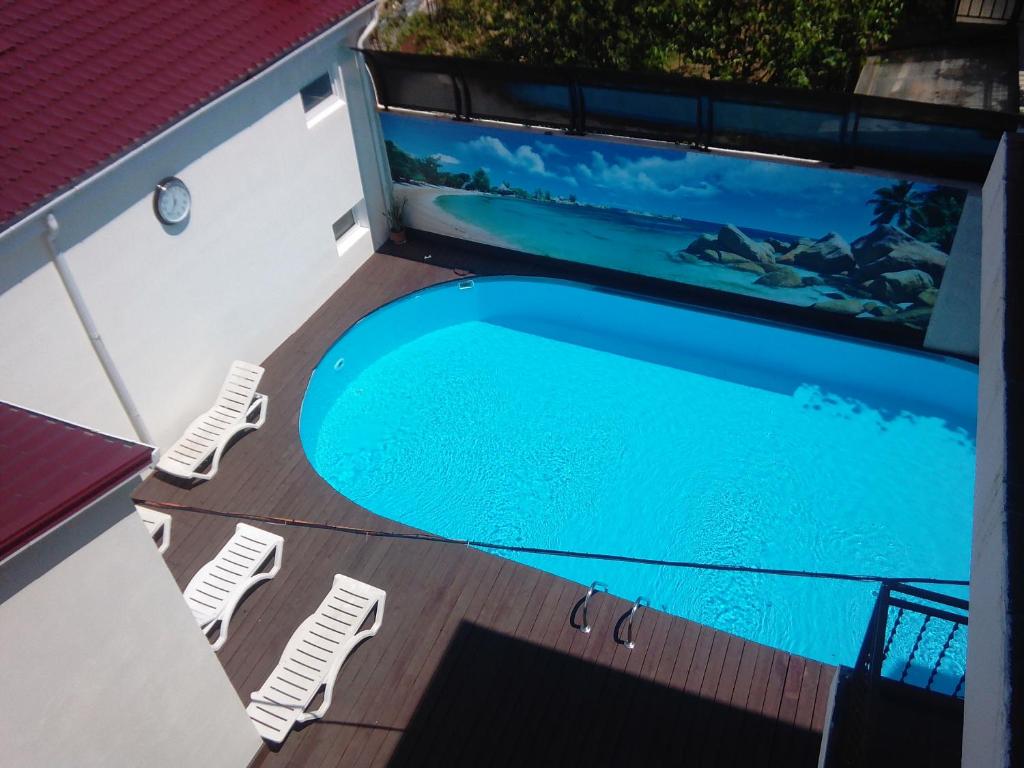 an overhead view of a swimming pool on a deck with lounge chairs at Guest House Na Mamayke + in Sochi