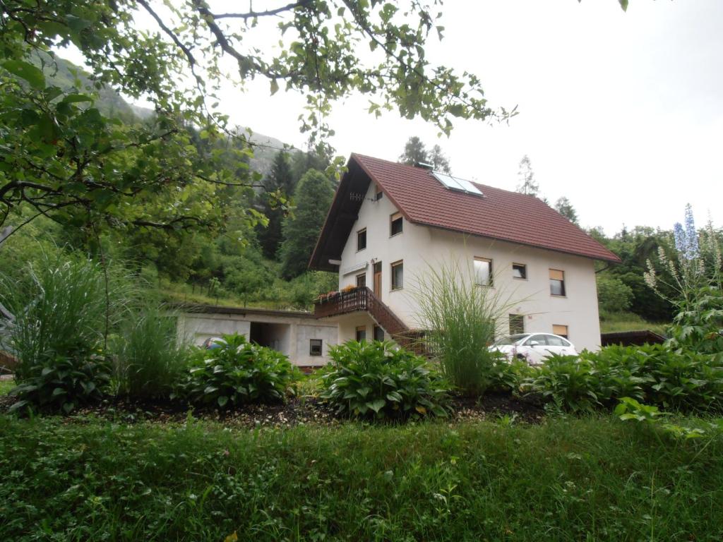 a house with a car parked in front of it at Apartment Vida in Bovec