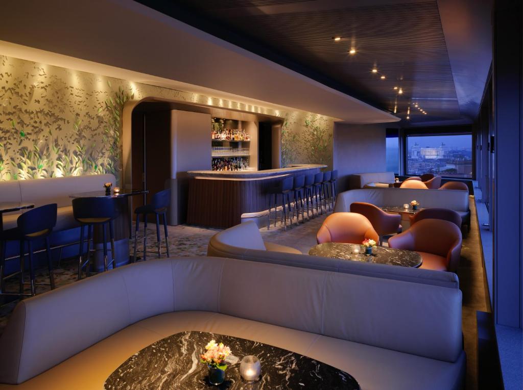 a lobby with a couch and a bar at Hotel Eden - Dorchester Collection in Rome