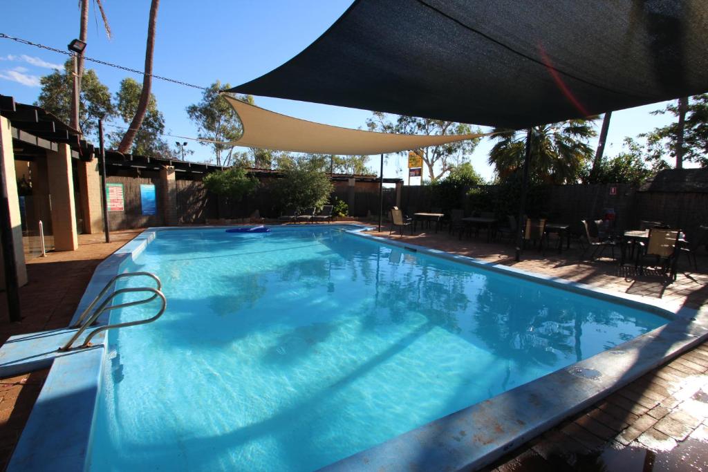 a large blue swimming pool with an umbrella at The Landing Port Hedland in Port Hedland