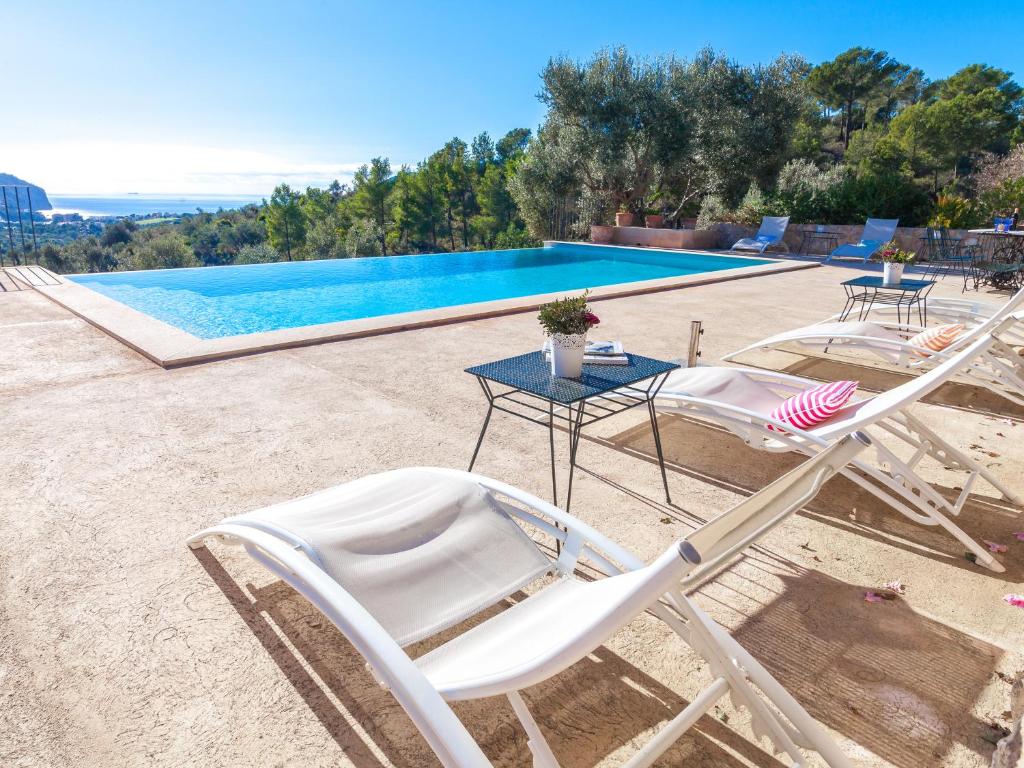un par de sillas de jardín sentadas junto a una piscina en Villa Finca Luisa para 6 con piscina y vista mar, en Andratx