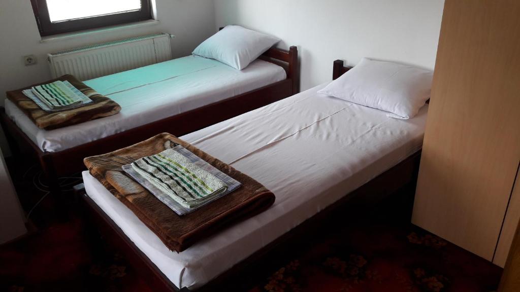 2 aparte bedden in een kamer met een dienblad bij Mico NP Guest House in Novi Pazar