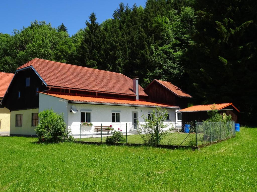 uma casa branca com um telhado vermelho num campo em Haus im Grünen - Gmundennähe em Pinsdorf