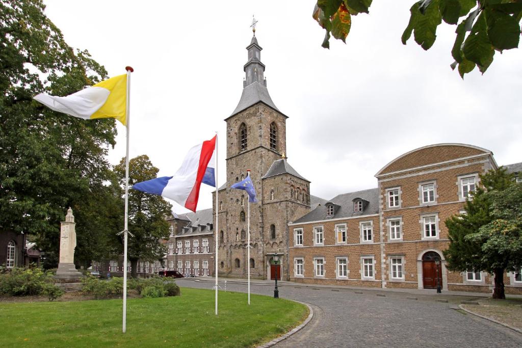 two flags on poles in front of a building at Abdij Hotel Rolduc in Kerkrade